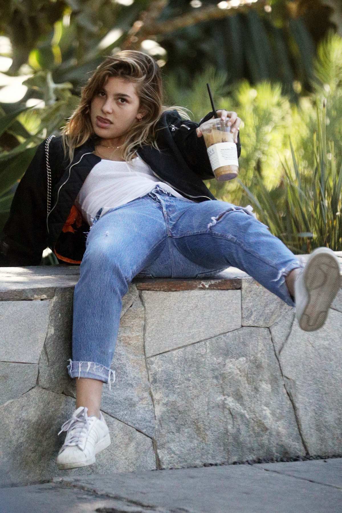 Camila Morrone almost loses balance while sitting on a wall at a park in Los Angeles