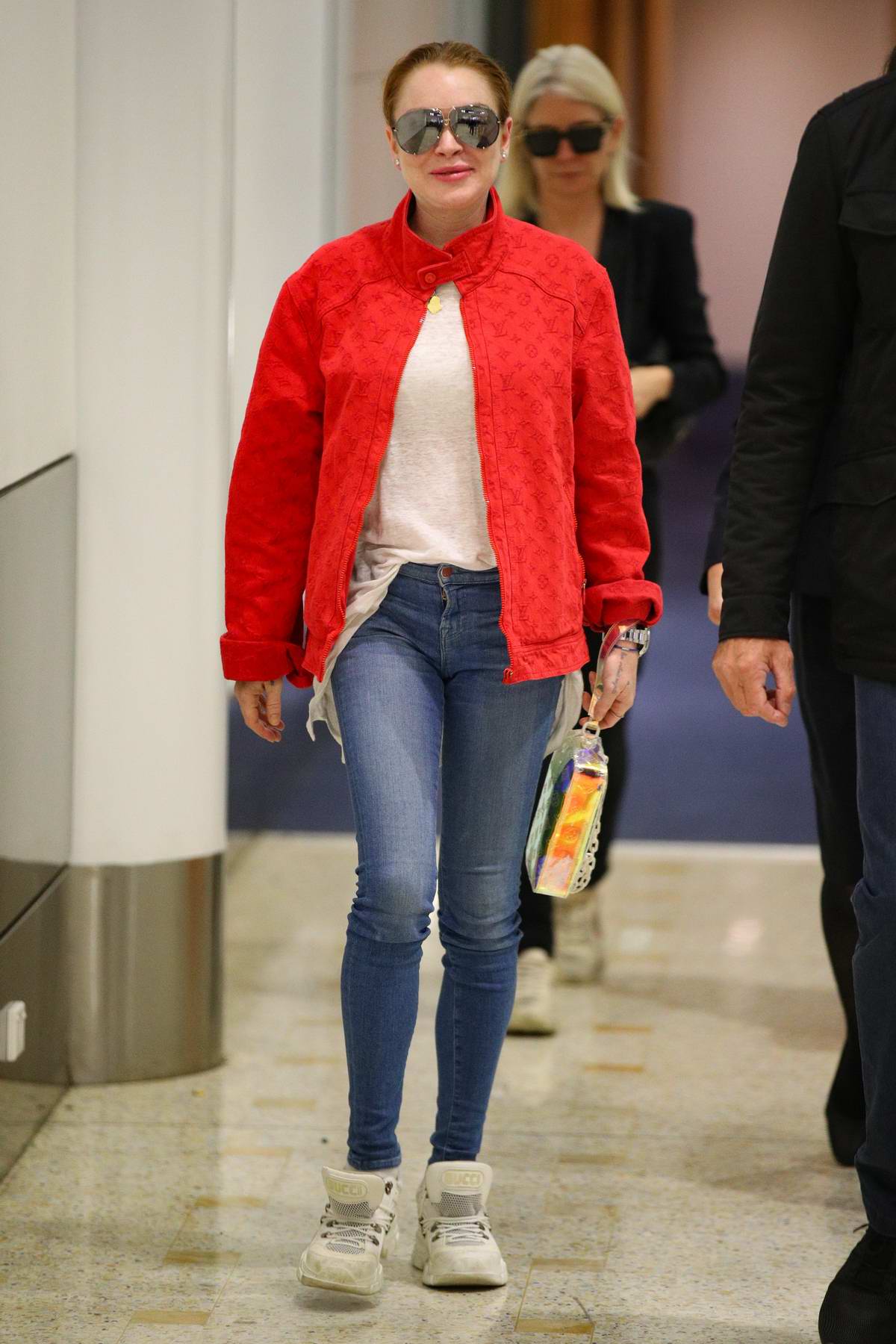 lindsay lohan stands out in a bright red jacket as she touches down at