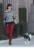 Nina Dobrev in a printed top and red leggings walking her dog in Los Angeles