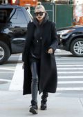 Hailey Baldwin dressed in black overcoat and leather pants as she visit Bella Hadid's apartment in New York City