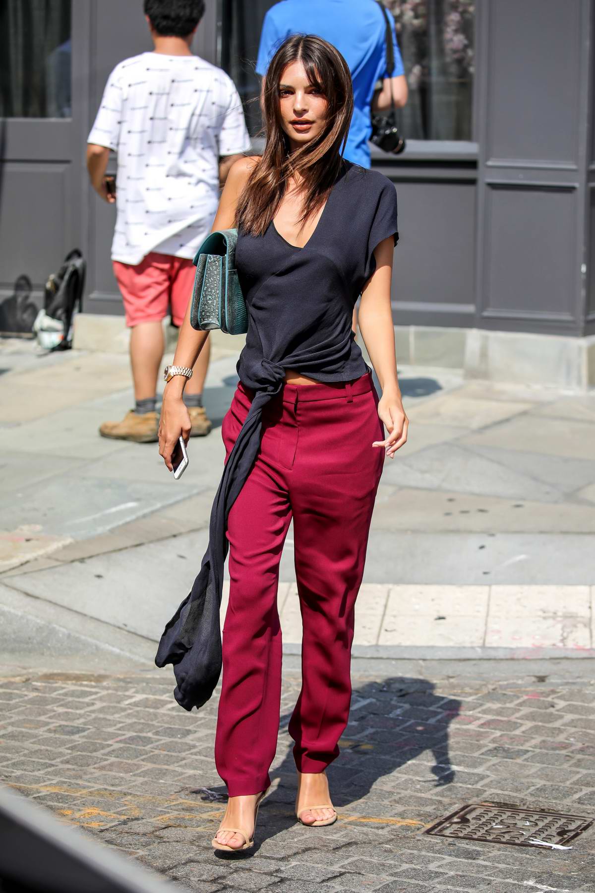 Emily Ratajkowski wears a navy blue top with dark pink pants as she heads  to a