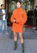 Sara Sampaio wears an orange dress with olive green suede boots as she heads out of Royal Monceau Hotel in Paris, France