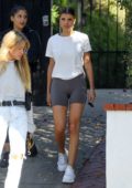 Sofia Richie wears a white top and biker shorts while out shopping with a friend in Los Angeles