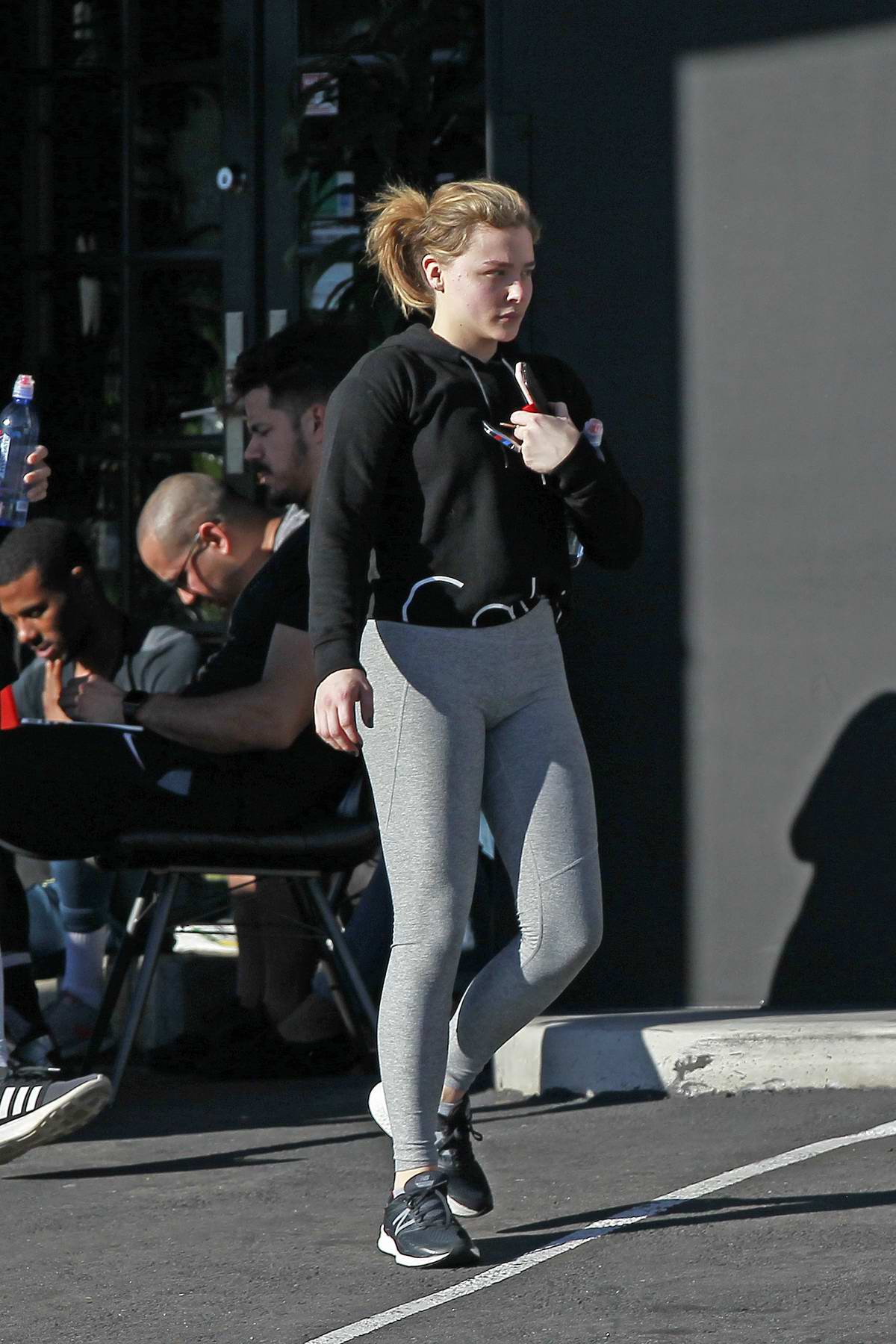 Chloe Grace Moretz wears a Calvin Klein hoodie and grey leggings as she  leaves the gym