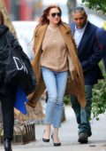 Lindsay Lohan seen wearing brown trench coat and studded jeans as she leaves her apartment in New York City