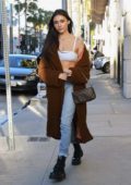 Madison Beer rocks a white bra top and jeans with brown long coat while out shopping on Rodeo Drive in Beverly Hills, Los Angeles