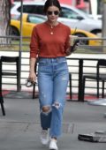 Lucy Hale wears an orange top and ripped jeans during a coffee run at Starbucks in Studio City, Los Angeles