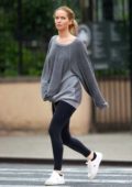 Jennifer Lawrence wears a grey sweatshirt and black leggings as she steps out for a stroll in light drizzle in New York City