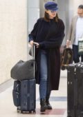 Anne Hathaway pushes her own luggage as she arrives for a flight at JFK Airport in New York City