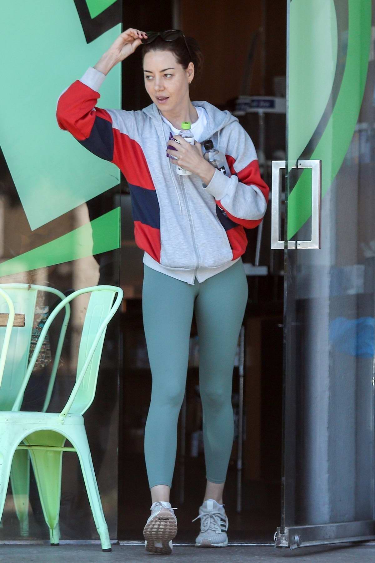 Aubrey Plaza wears an Adidas hoodie and teal leggings while out for a  stroll with her