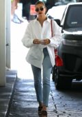 Hailey Bieber sports a white shirt and blue jeans while visiting a skincare clinic in Beverly Hills, California