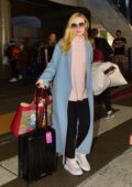 Elle Fanning carries a colorful Gucci bag as she touches down at LAX airport in Los Angeles