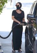 Nikki Bella shows her baby bump in a form-fitting black dress while stopping for gas at a gas station in Studio City, California