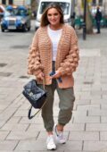 Kelly Brook looks cozy in a knitted cardigan as she arrives for her Heart radio show in London, UK