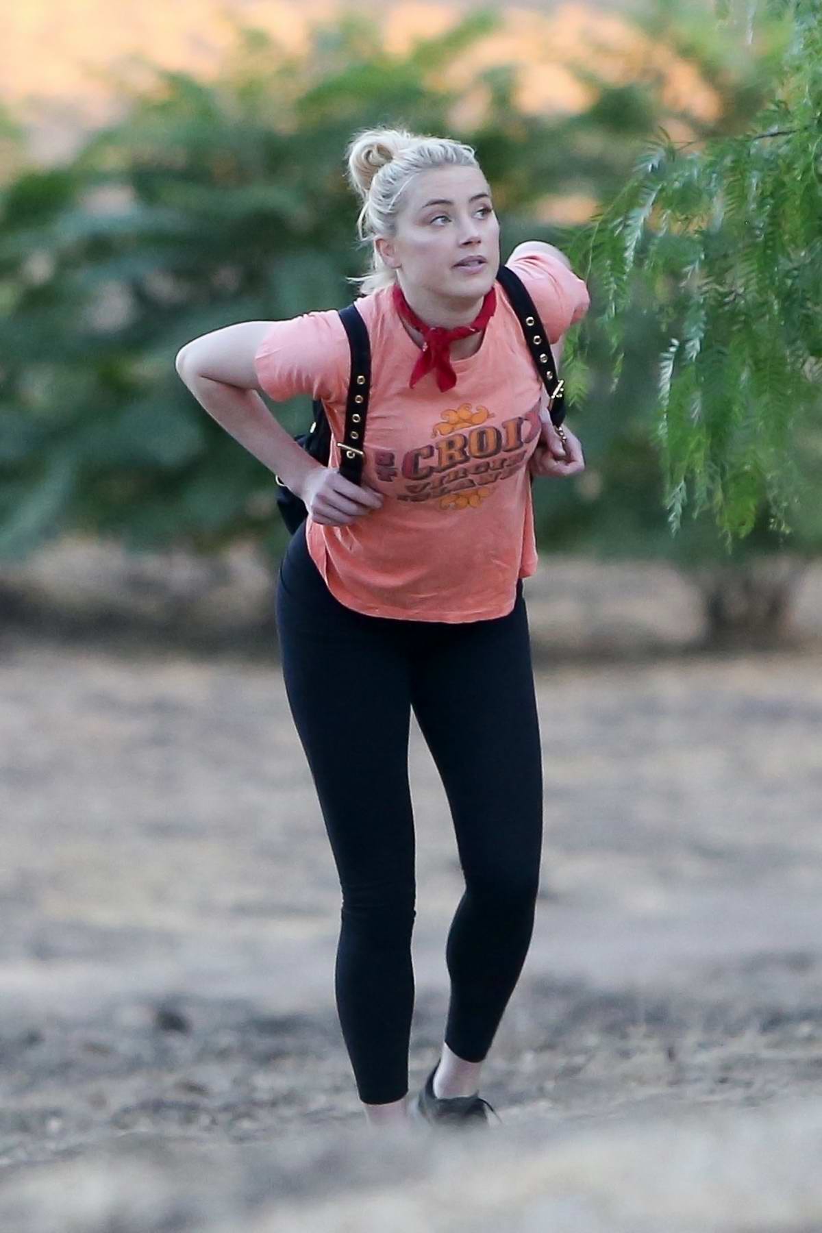 Amber Heard wears a pink tee and black leggings for an afternoon hike with her dog