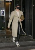 Hailey Bieber looks stylish in a beige trench coat and black leather pants as she heads out of her apartment in New York City