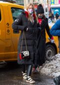 Martha Hunt bundles up in a long puffer coat as she returns to her hotel after a photoshoot in New York City