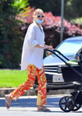 Elsa Hosk wears an oversized shirt and patterned orange pants while heading out for coffee with her daughter in Los Angeles