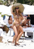 Joy Corrigan dons a floral print bikini and huge sunhat while enjoying the beach in Miami, Florida