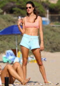 Alessandra Ambrosio showcases her beach body in a sports bra and shorts during a beach volleyball game in Santa Monica, California