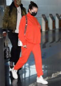Selena Gomez keeps it comfy in bright orange sweatsuit and white sneakers while arriving at JFK Airport in New York City
