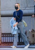 Scarlett Johansson wears a face mask with a blue sweater and striped trousers while out in Midtown, New York City