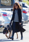 Sarah Hyland wears black skinny jeans with a matching coat and striped top while she takes her dog to the vet in Los Angeles