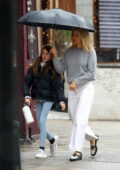 Sienna Miller wears a grey top and white denim while stepping out to pick up her daughter on a rainy day in New York City