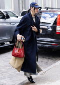 Dua Lipa dons a trench coat with denim dress and black boots while heading out in New York City