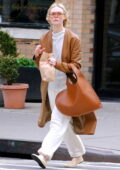 Elle Fanning dons a tan coat with her all-white outfit while out shopping in SoHo, New York City
