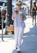 Ashley Benson wears a striped shirt and white denim while she grabs a green juice in Beverly Hills, California