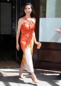 Olivia Munn looks radiant in an orange dress while heading out of her hotel in New York City