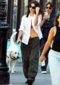Emily Ratajkowski shows off her killer abs in an unbuttoned shirt over a sports bra and low-rise pants while out in New York City