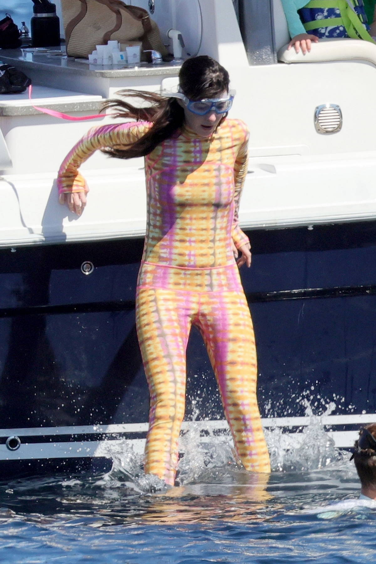 Anne Hathaway wears a tie-dye bodysuit as she goes for swim in the ocean while enjoying her vacation in Sardinia, Italy
