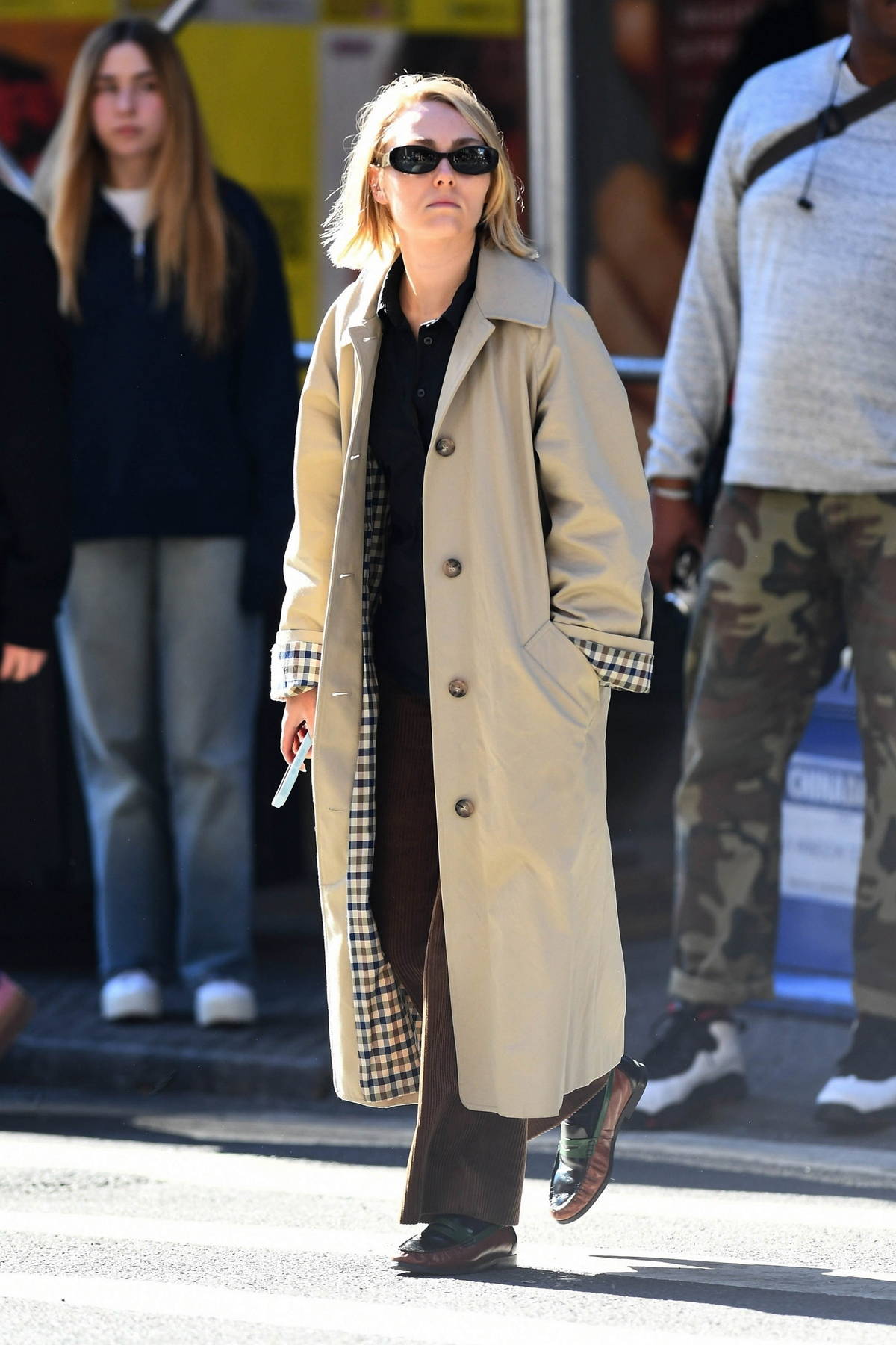 AnnaSophia Robb wears beige trench coat during a solo outing in New York City