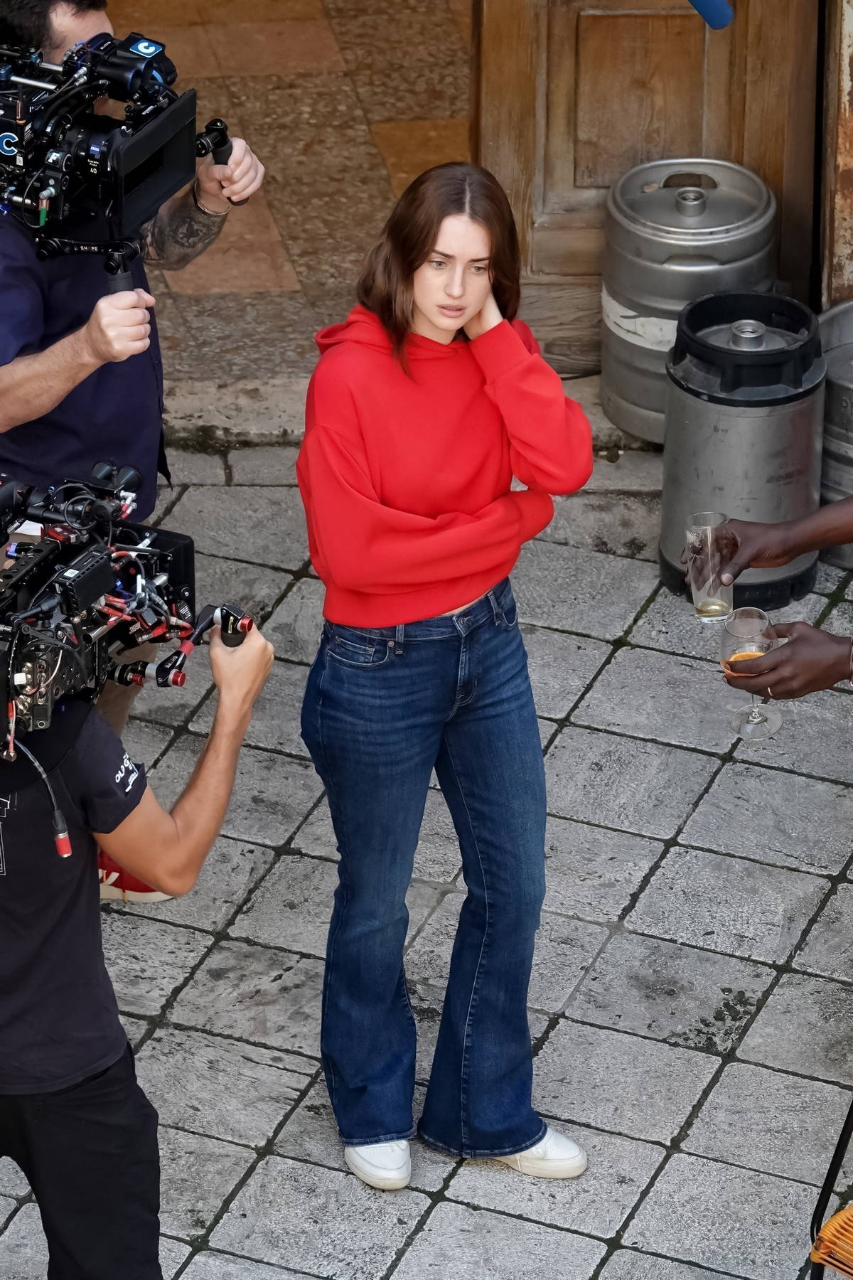 Grace Van Patten seen wearing a red hoodie and blue jeans while filming for the upcoming TV series 'Blue Moon' in Tivoli, Italy