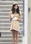 Kaia Gerber sports a prosthetic baby bump underneath a gold dress while filming a scene for 'Palm Royale' in New York City