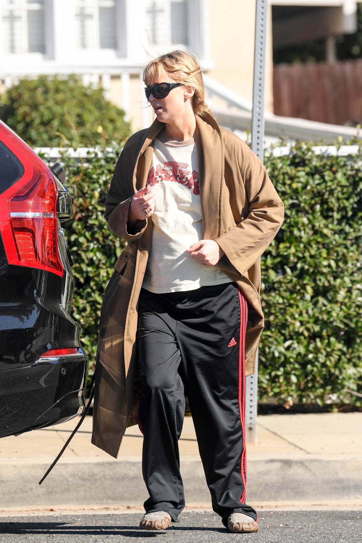 Jennifer Lawrence wears a khaki trench coat with a t-shirt and joggers while out in Los Angeles
